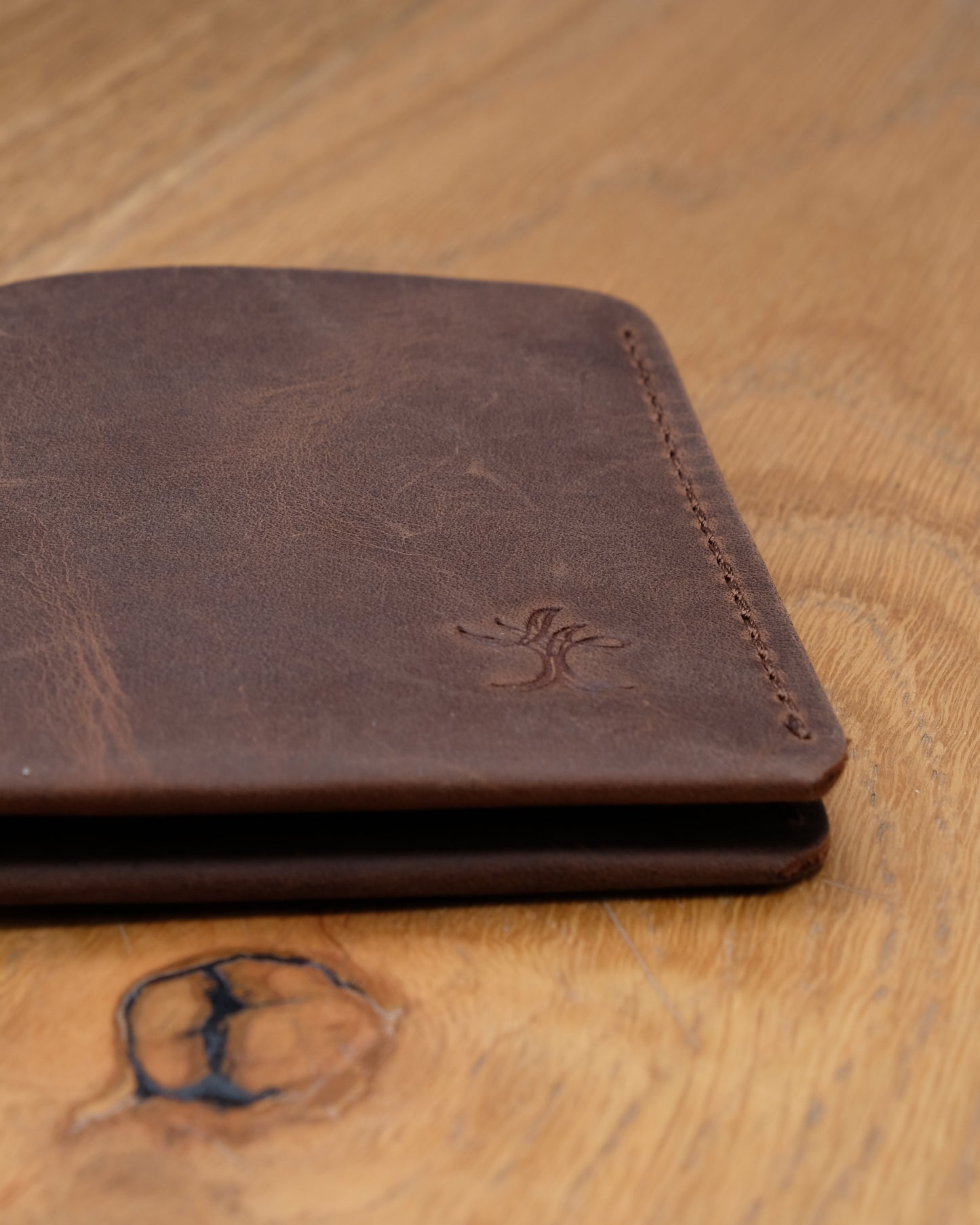 Close-up of brown top grain crazy leather Card Holder showing leather texture, stitching and embossed logo