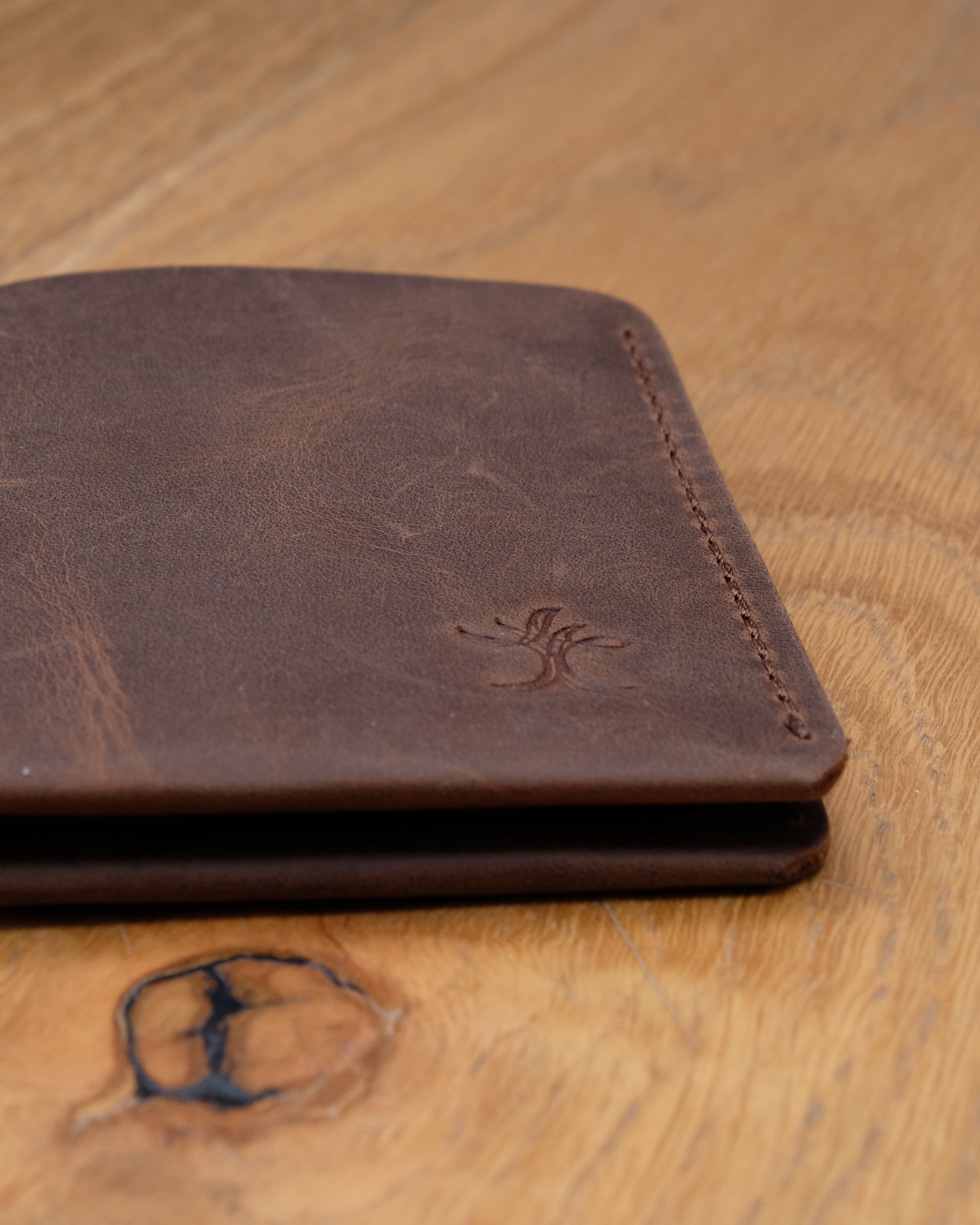Close-up of brown top grain crazy leather Card Holder showing leather texture, stitching and embossed logo