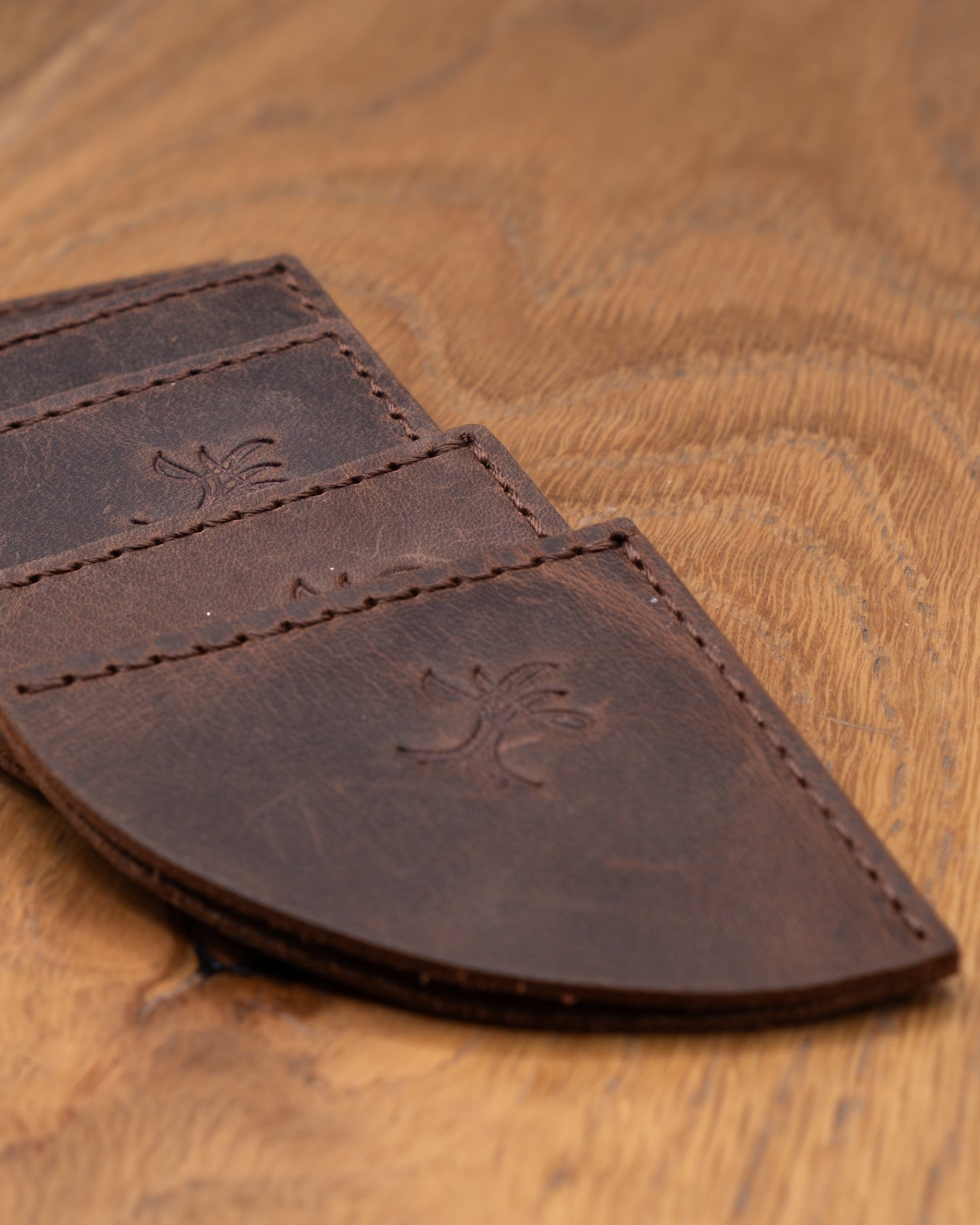 Close-up of brown top grain crazy leather corner bookmarks on a wooden surface