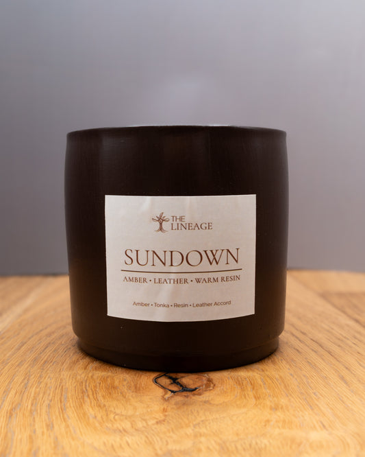 Sundown hand-poured soy candle with amber, tonka, resin and leather scent on a wooden surface