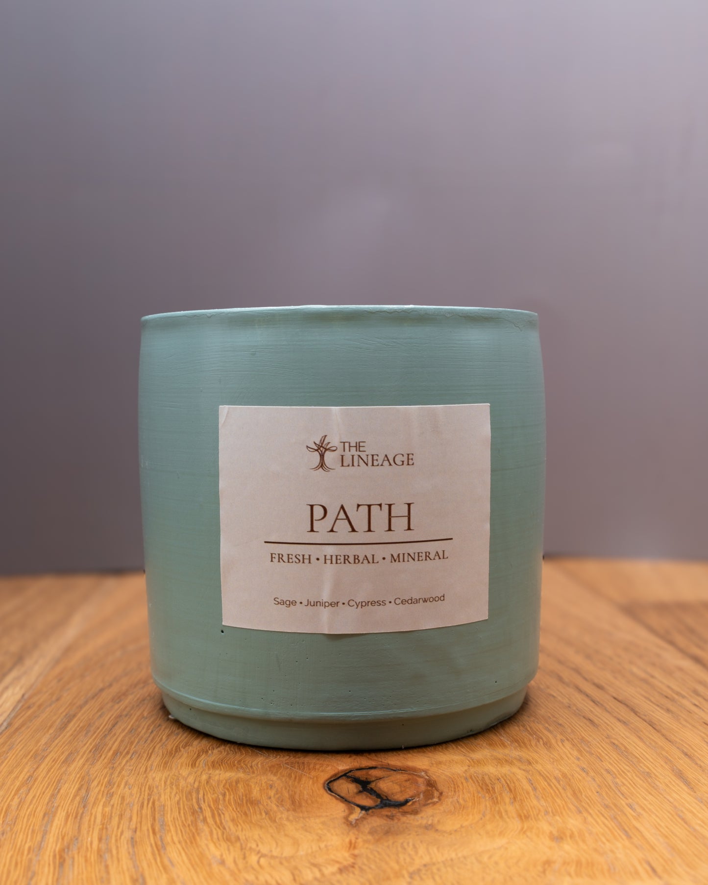 Path hand-poured soy candle with sage, juniper, cypress and cedarwood scent on a wooden surface