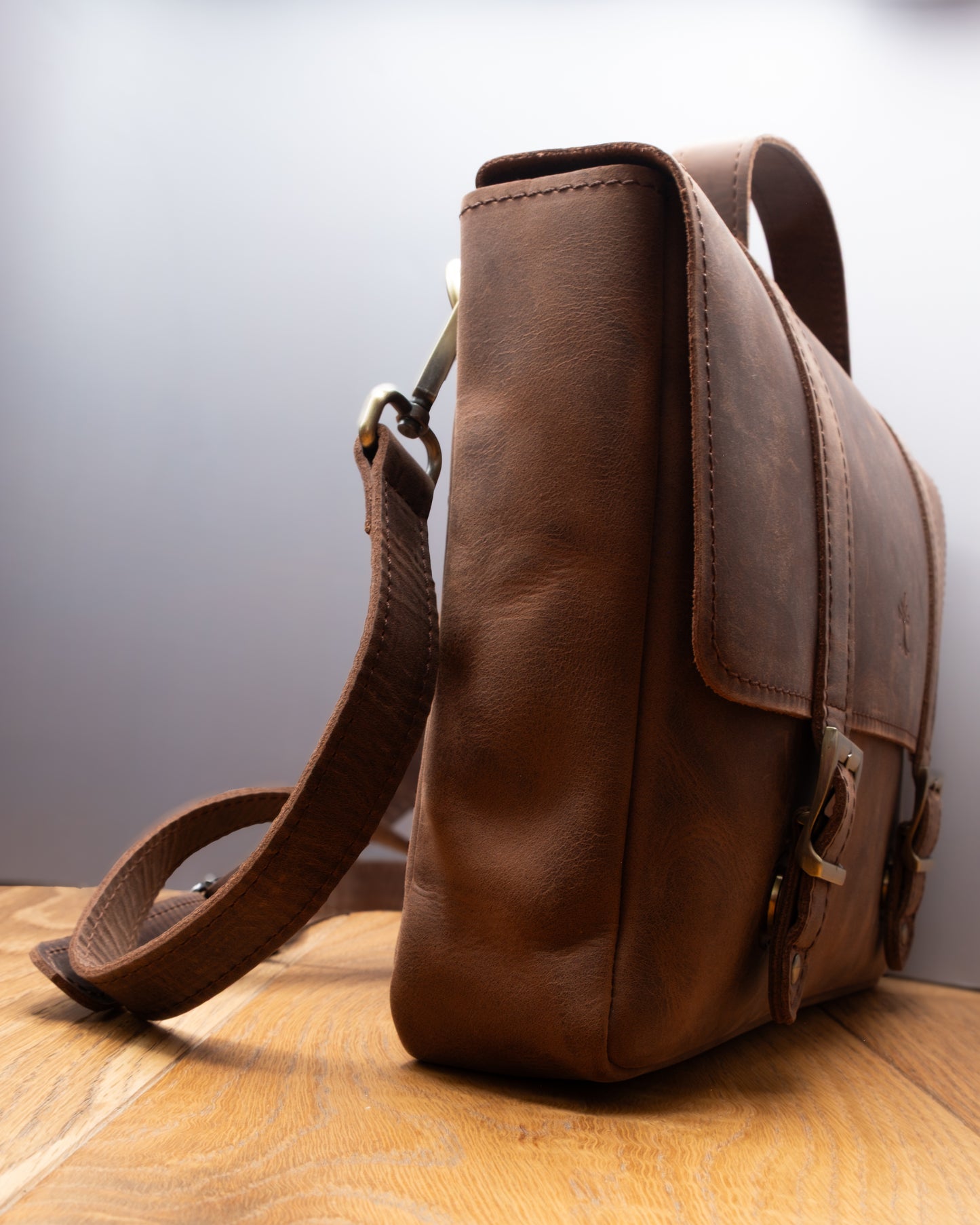 Side view of Postman Bag in brown Top Grain Crazy Leather with adjustable shoulder strap