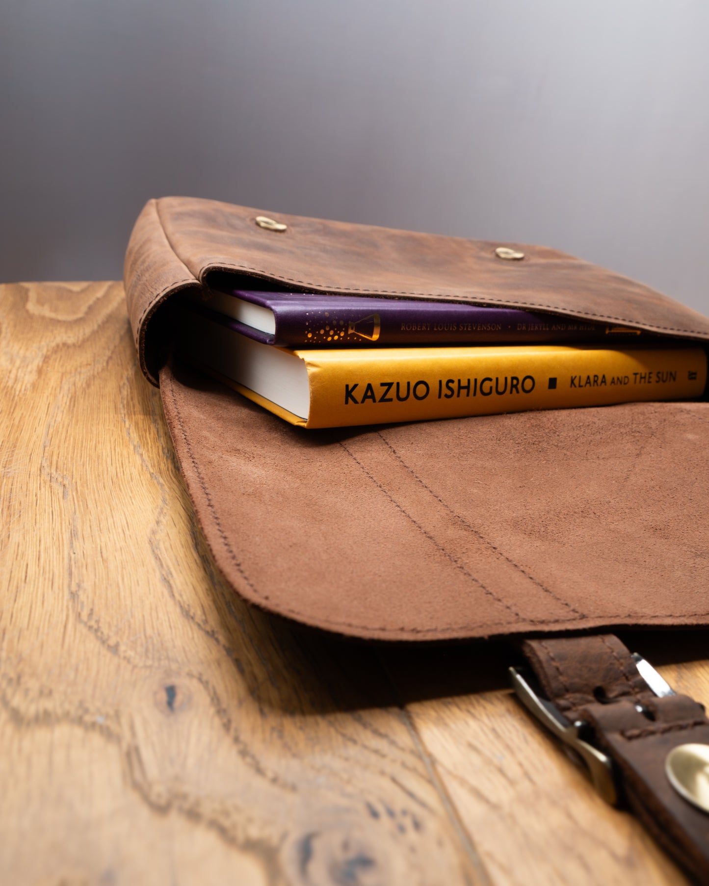 Open Postman Bag in brown Top Grain Crazy Leather showing spacious interior with books