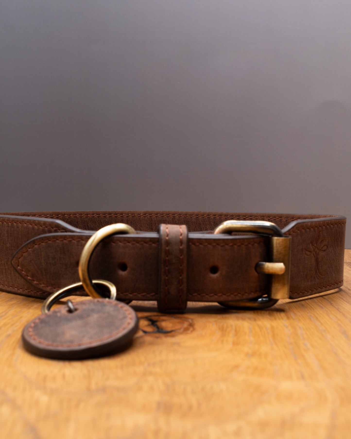 Close-up of brown top grain crazy  leather Dog Collar showing stitching, brass buckle and D-ring details