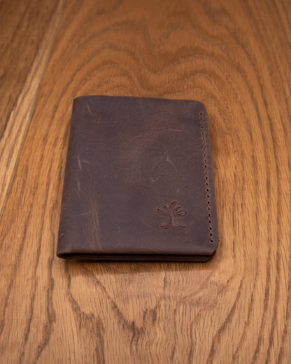 Brown top grain crazy leather Card Holder shown from a wider front view on a wooden surface